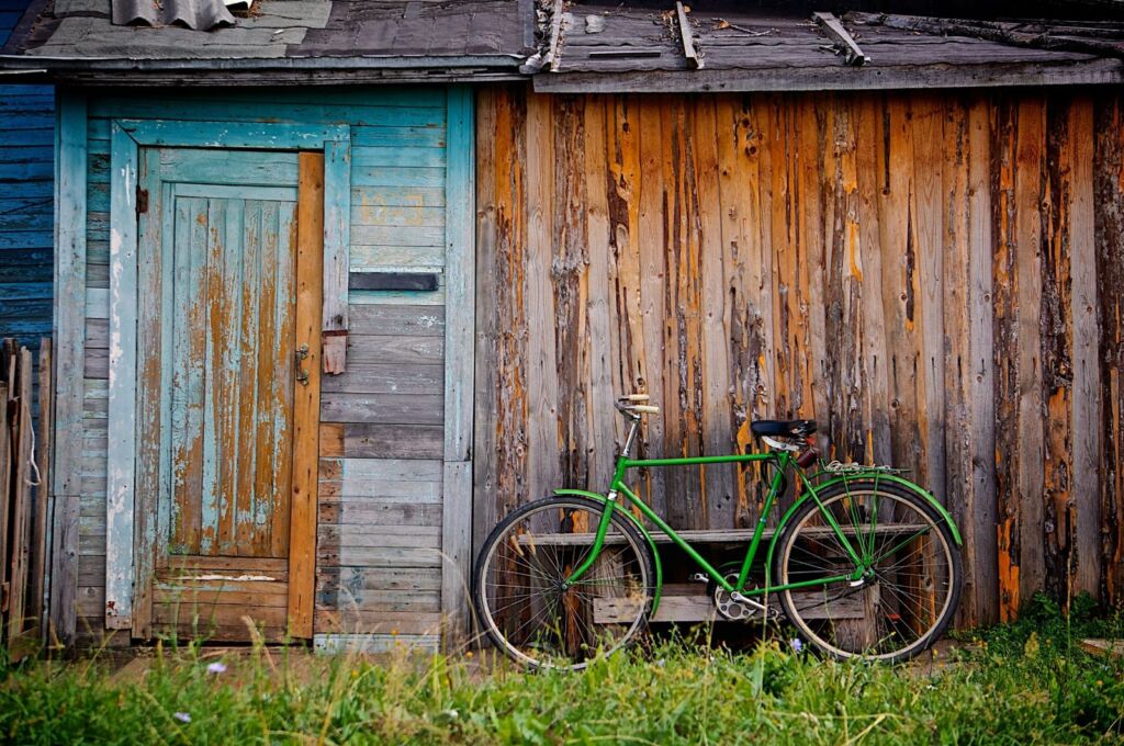 Old shed with a bike resting on it in need of demolition services.